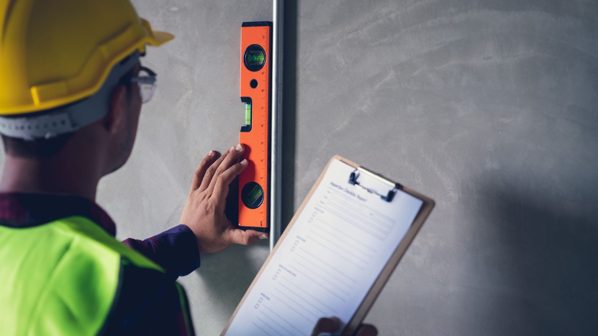 construction worker leveling a wall with a building code violations inspection checklist